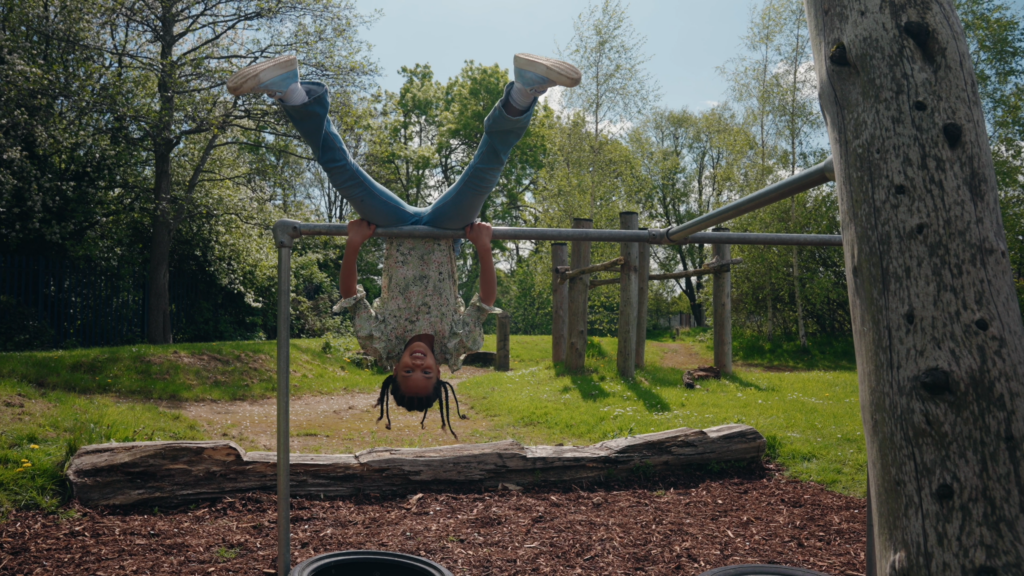Child hanging upside down in park